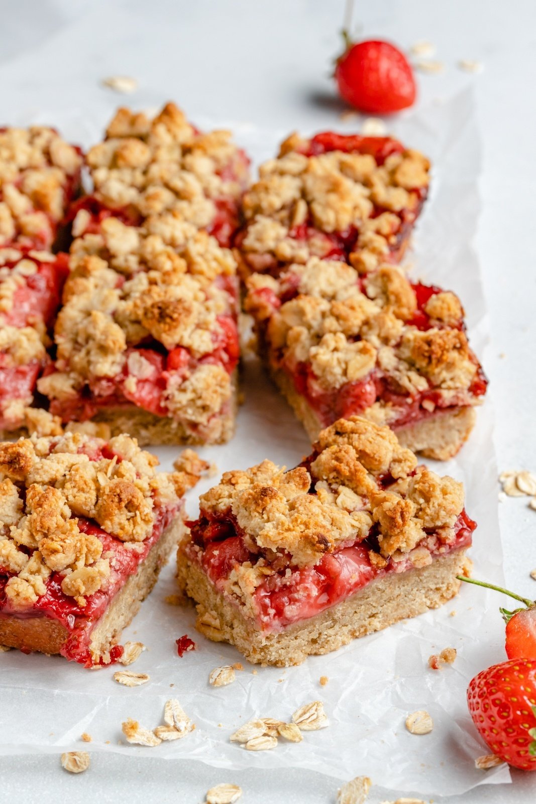 gluten free strawberry crumble bars on parchment paper