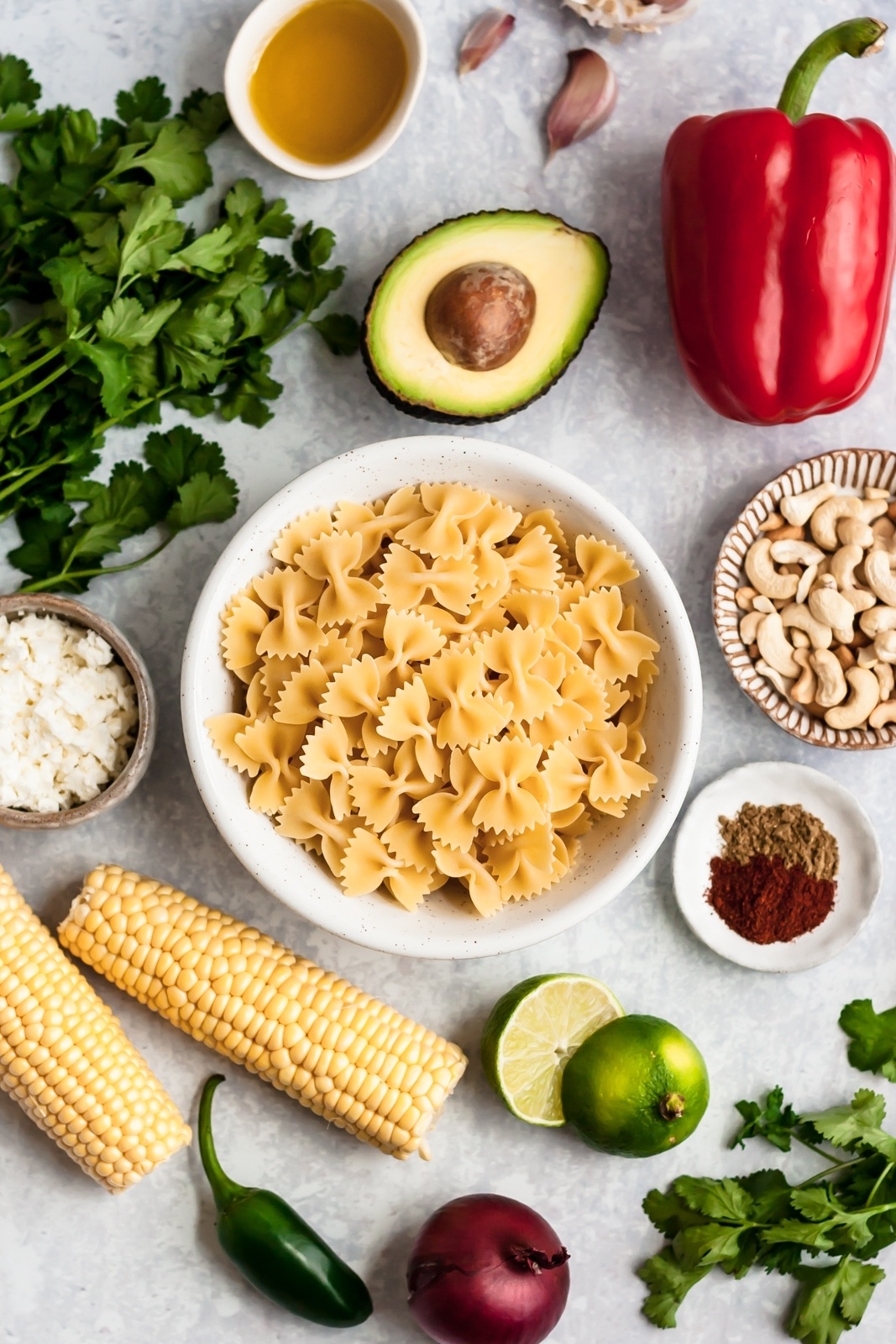 Mexican street corn pasta salad ingredients on a grey surface