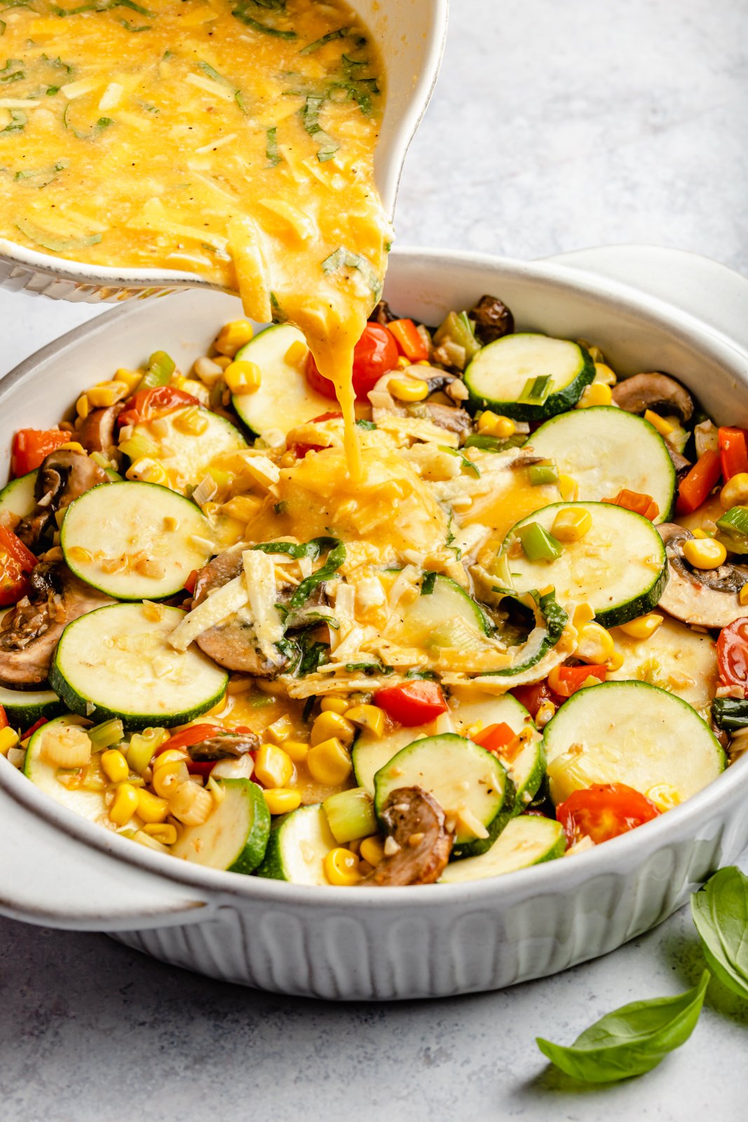 pouring eggs into a pan to make a zucchini pie