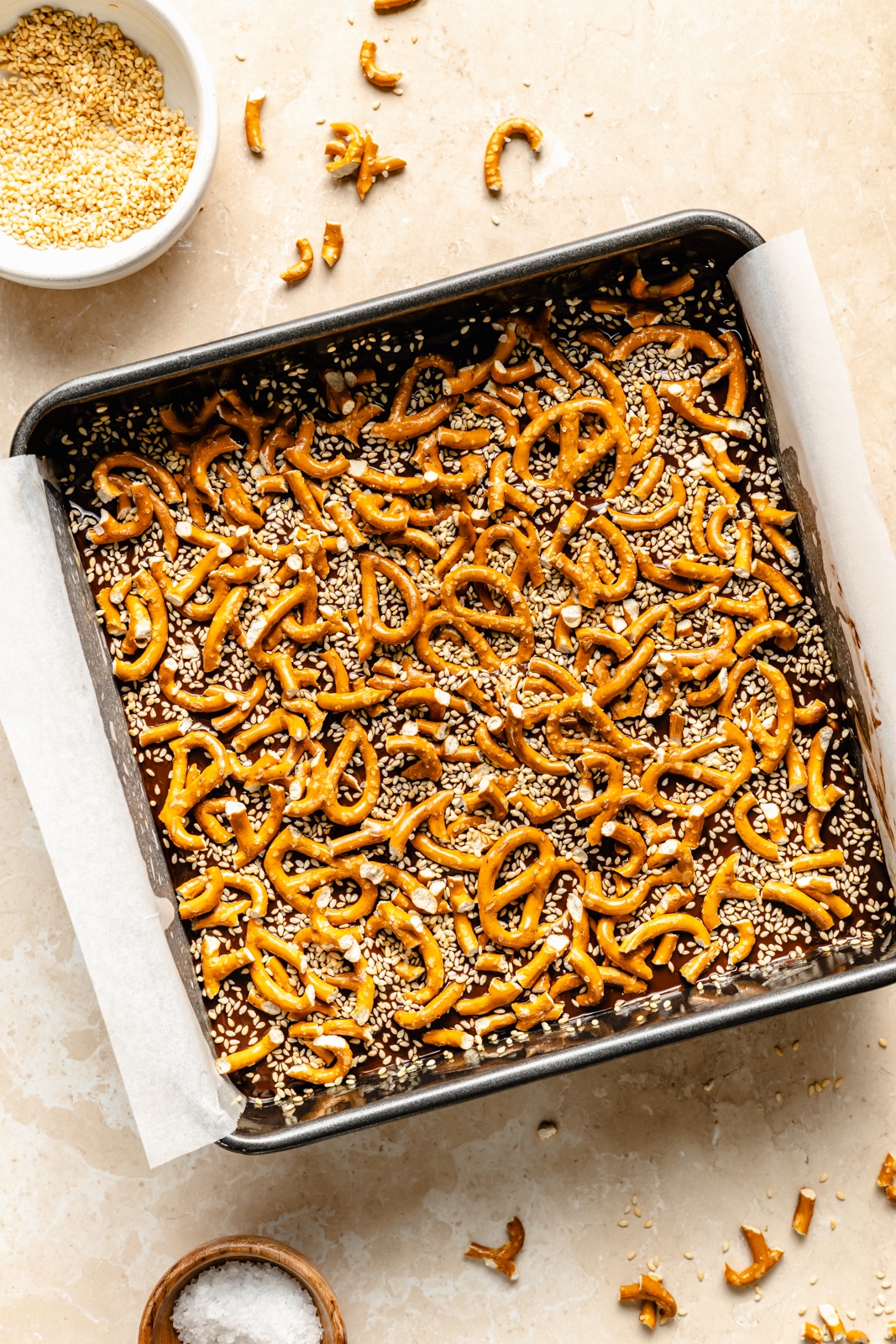 chocolate tahini rice krispie treats topped with pretzels in a pan