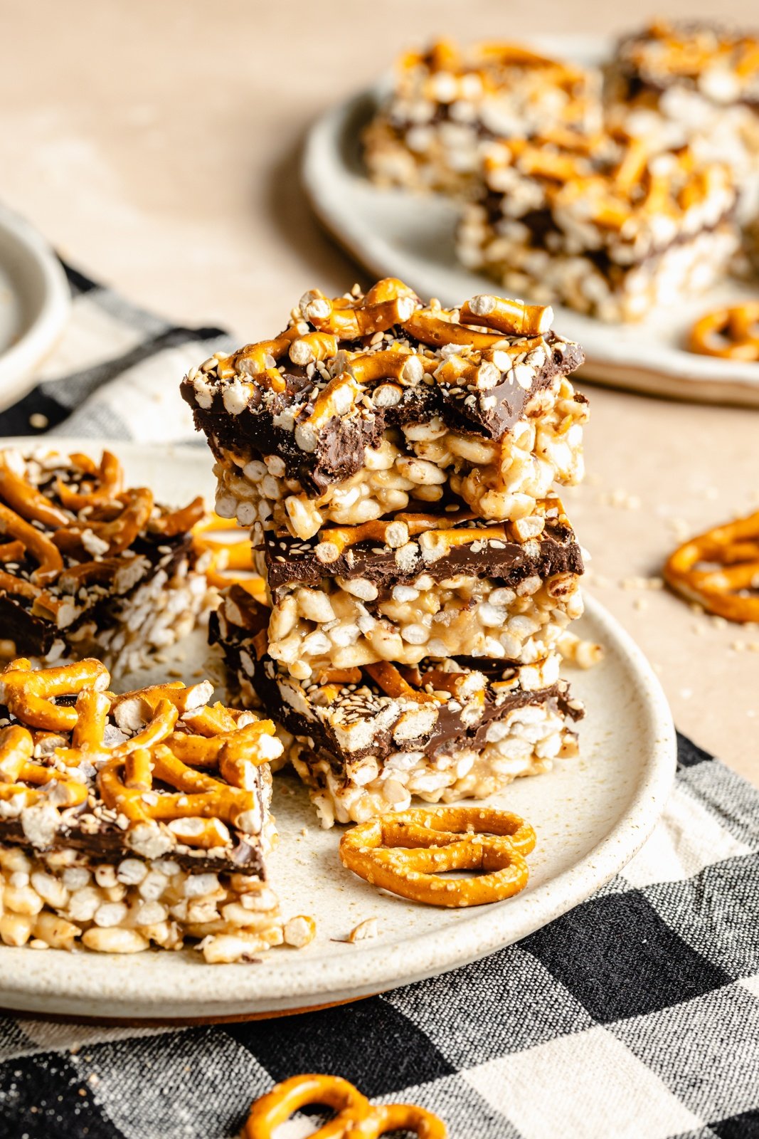 tahini rice krispie treats topped with pretzels and chocolate in a stack