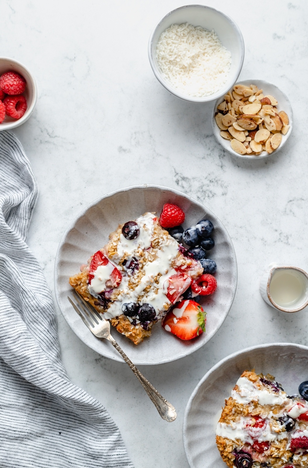 slice of berry baked oatmeal on a plate with berries