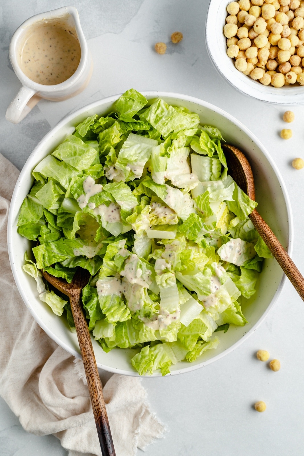 tossing a healthy vegan caesar salad in a bowl