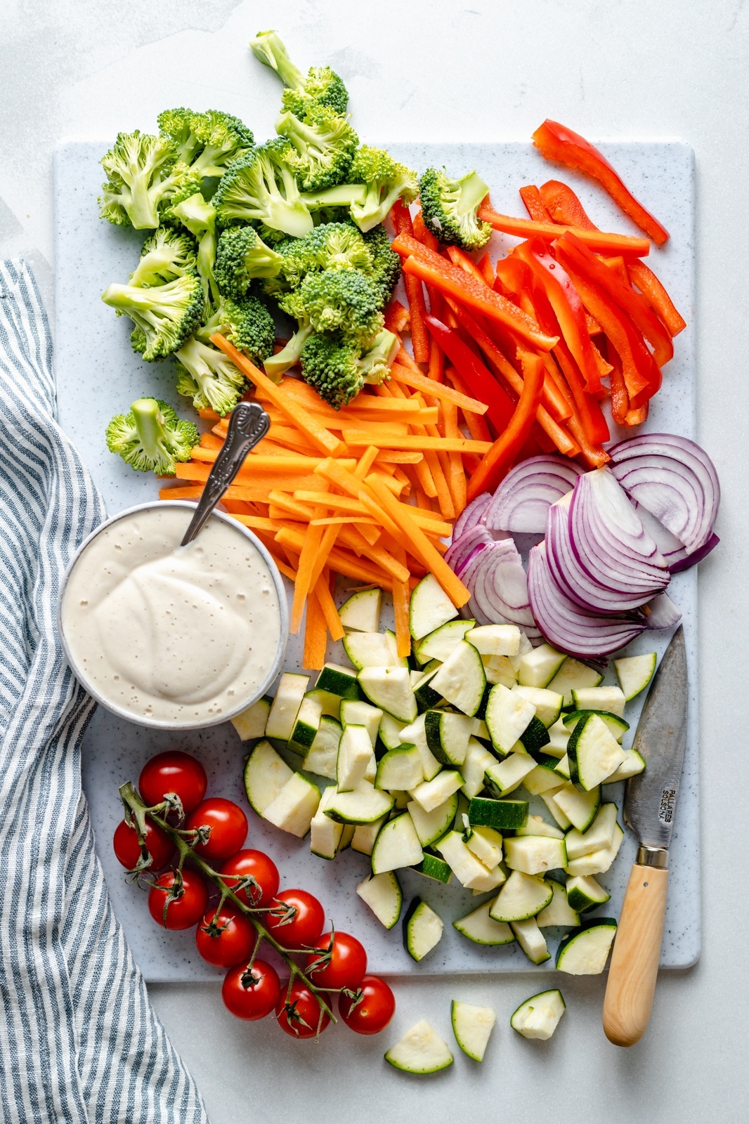 vegetables and sauce laid out on a board to make vegan pasta primavera