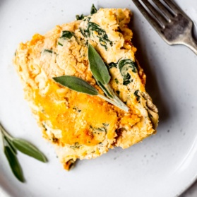 slice of vegan lasagna on a plate with a fork