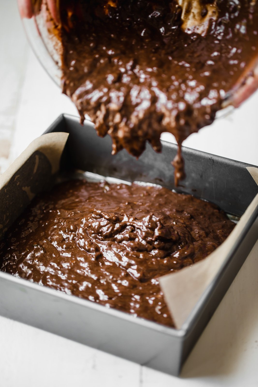 batter for the best zucchini brownies being poured into a pan